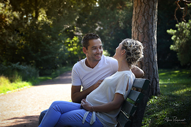 Photo d'un couple discutant sur un banc, la femme est enceinte.