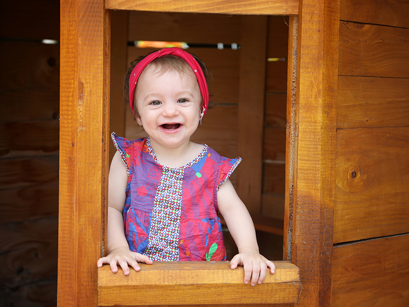 Photo d'une petite fille heureuse dans une cabane en bois